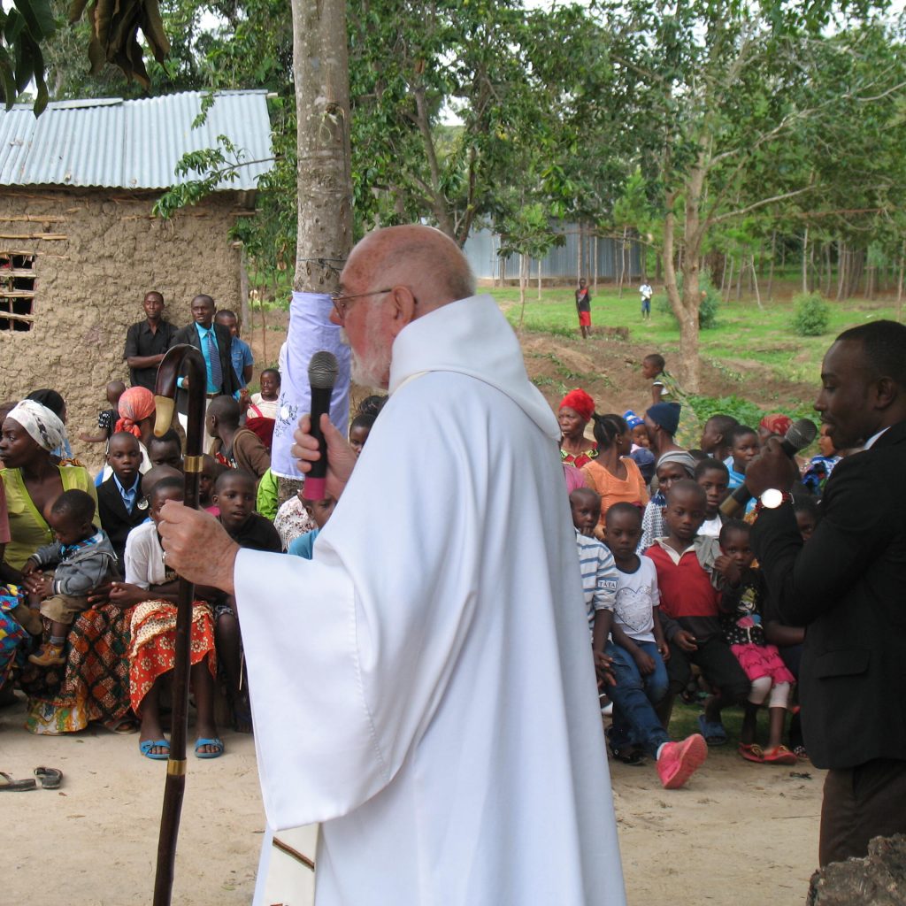 Outdoor Mass in rural Kenya – Apostolic Catholic Church ministry Apostolic Catholic Church bishop preaching at outdoor Mass in rural Kenya with local families and children